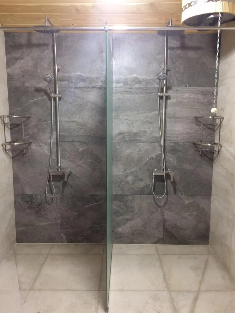Douche met twee douchesets achter een glazen wand
