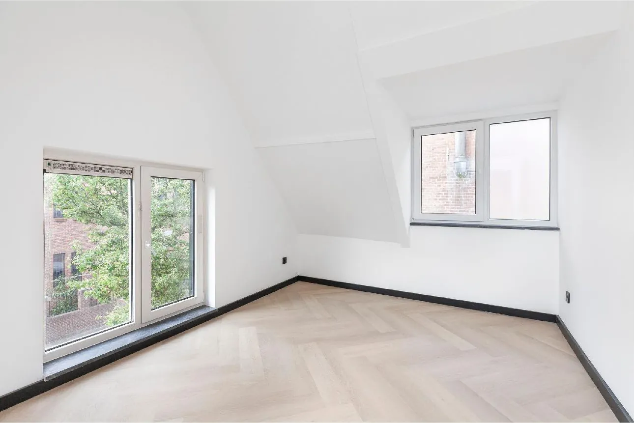Lichte kamer met visgraatvloer en ramen