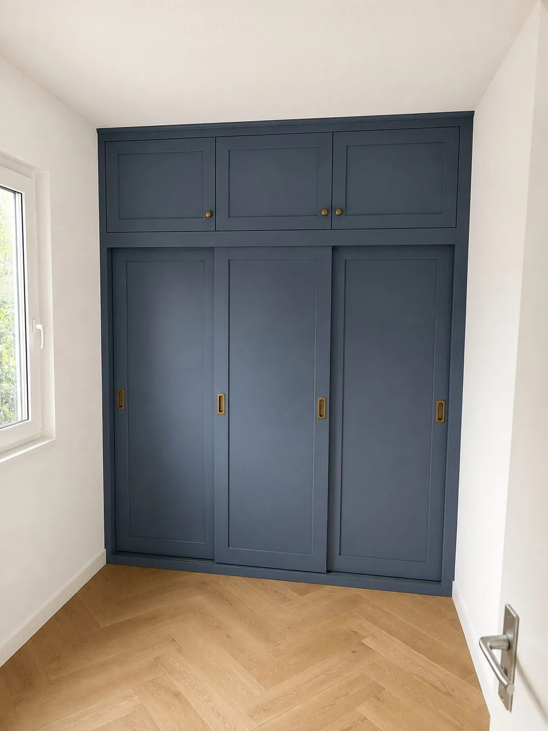 Inbouwkast in donkerblauwe kleur geschilderd met visgraatvloer