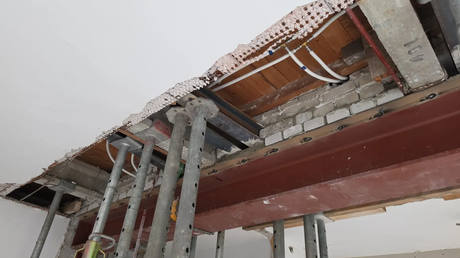 Stalen ligger en stempels onder een geopend plafond tijdens een verbouwing
