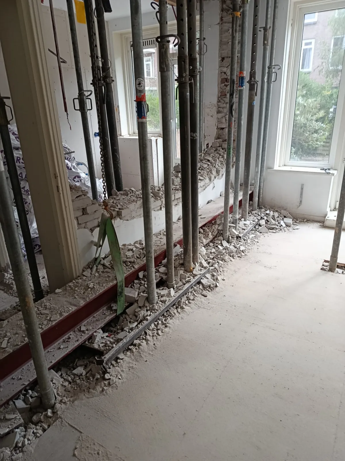 Rij stempels onder een nieuwe stalen ligger in een woonkamer