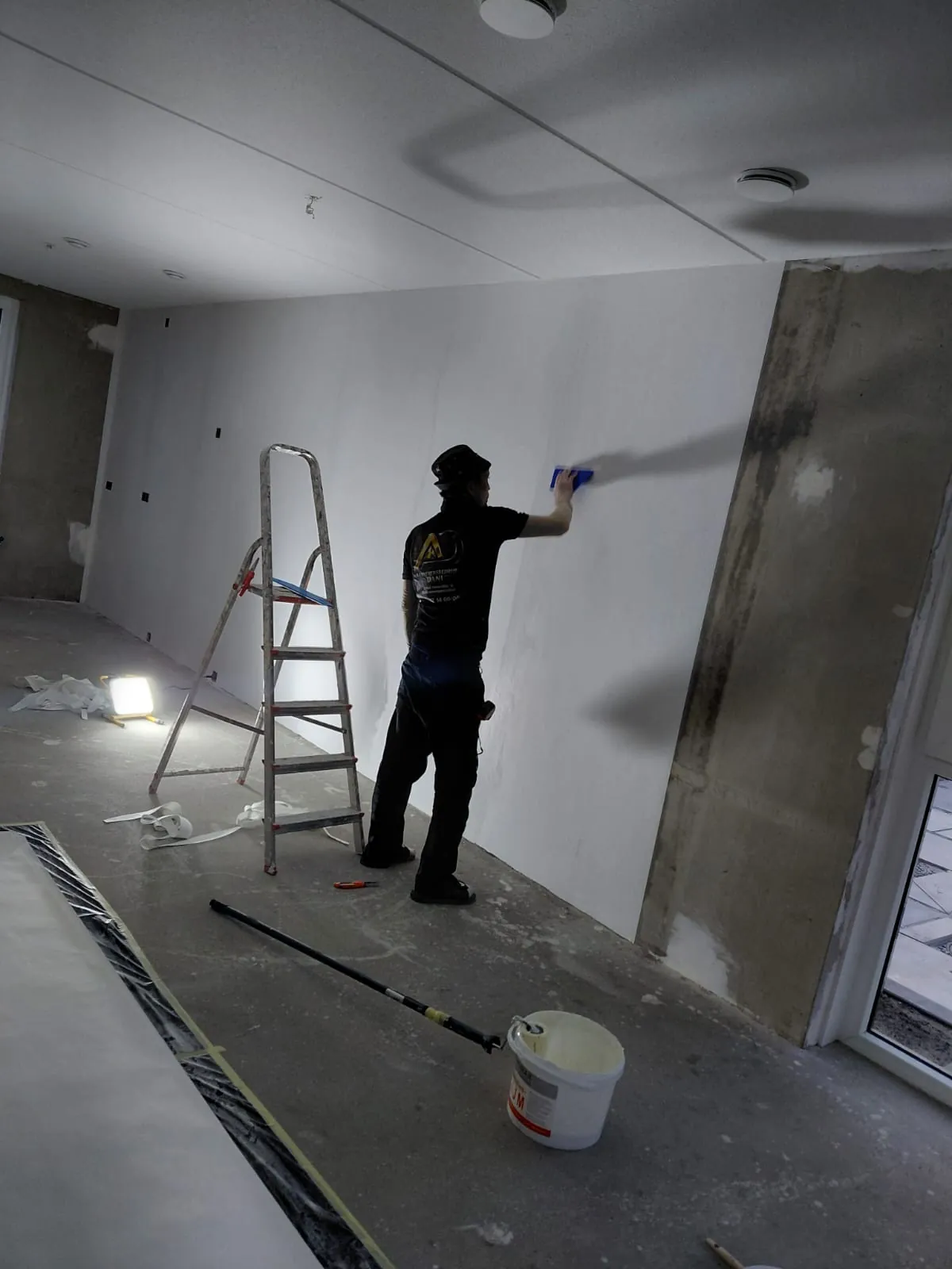 Stukadoor werkt een wand af in een woning in renovatie