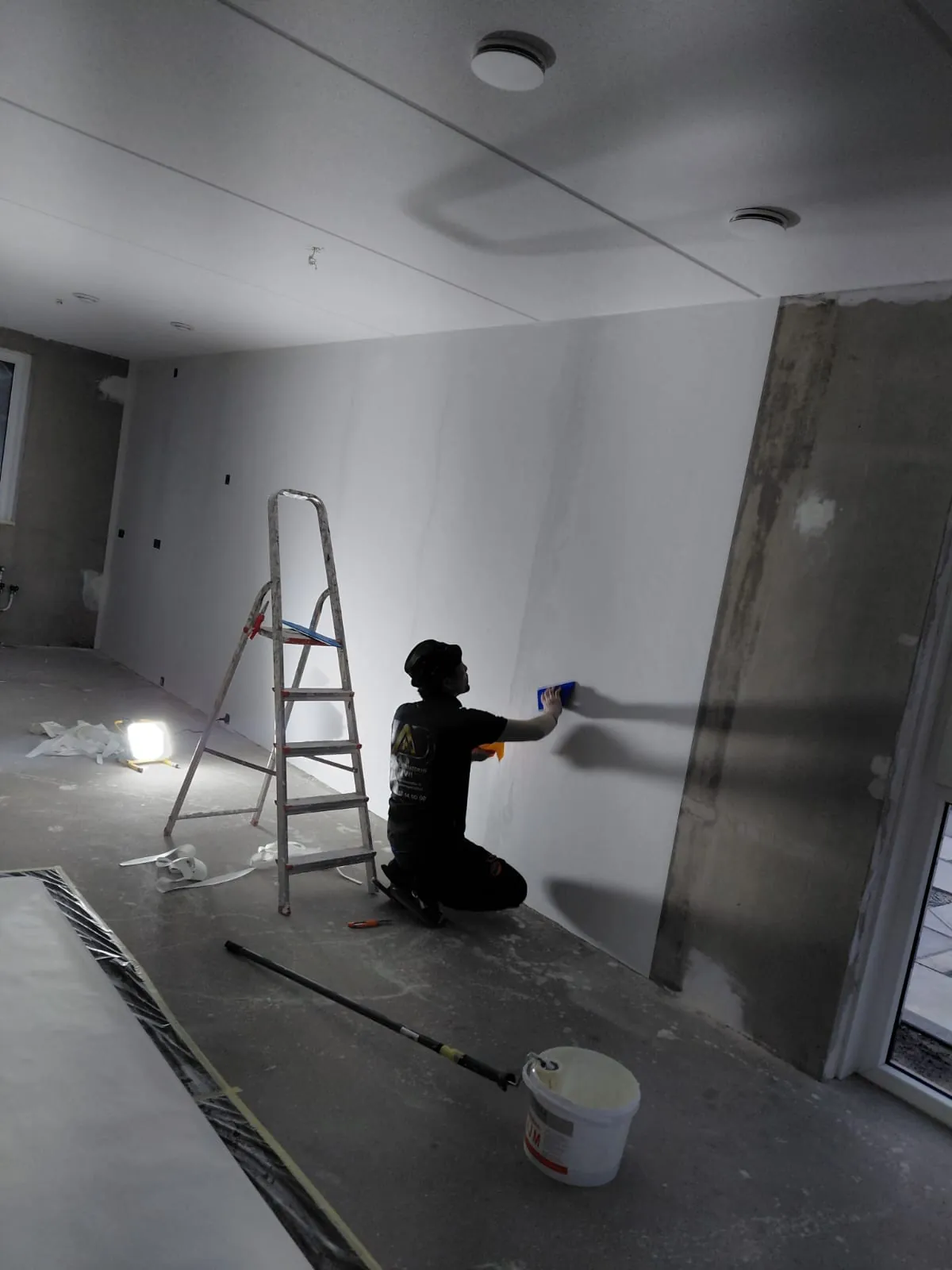 Wand wordt afgewerkt tijdens een renovatie in een lichte ruimte