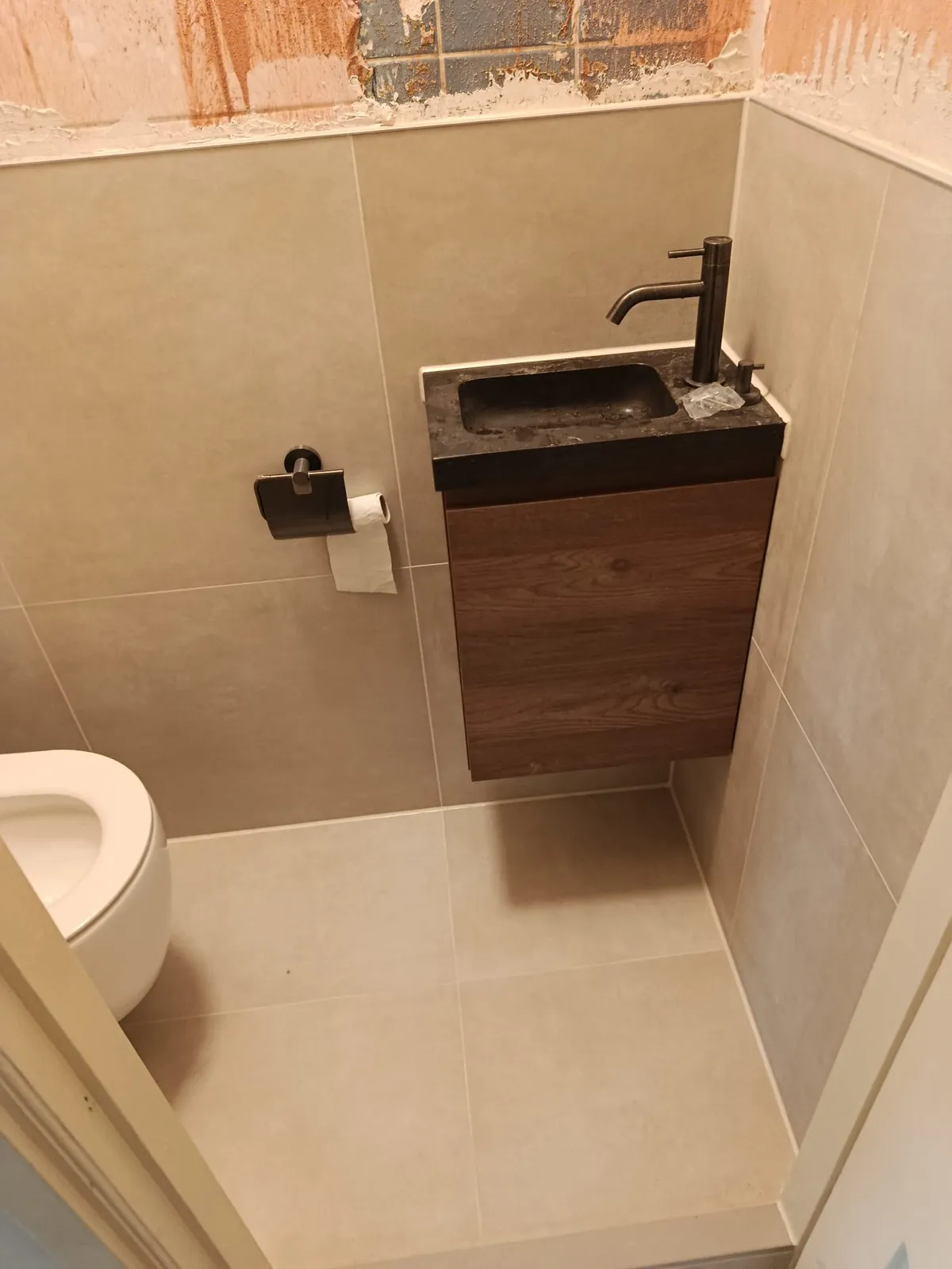 Toilet met houten fonteinkastje en zwarte kraan