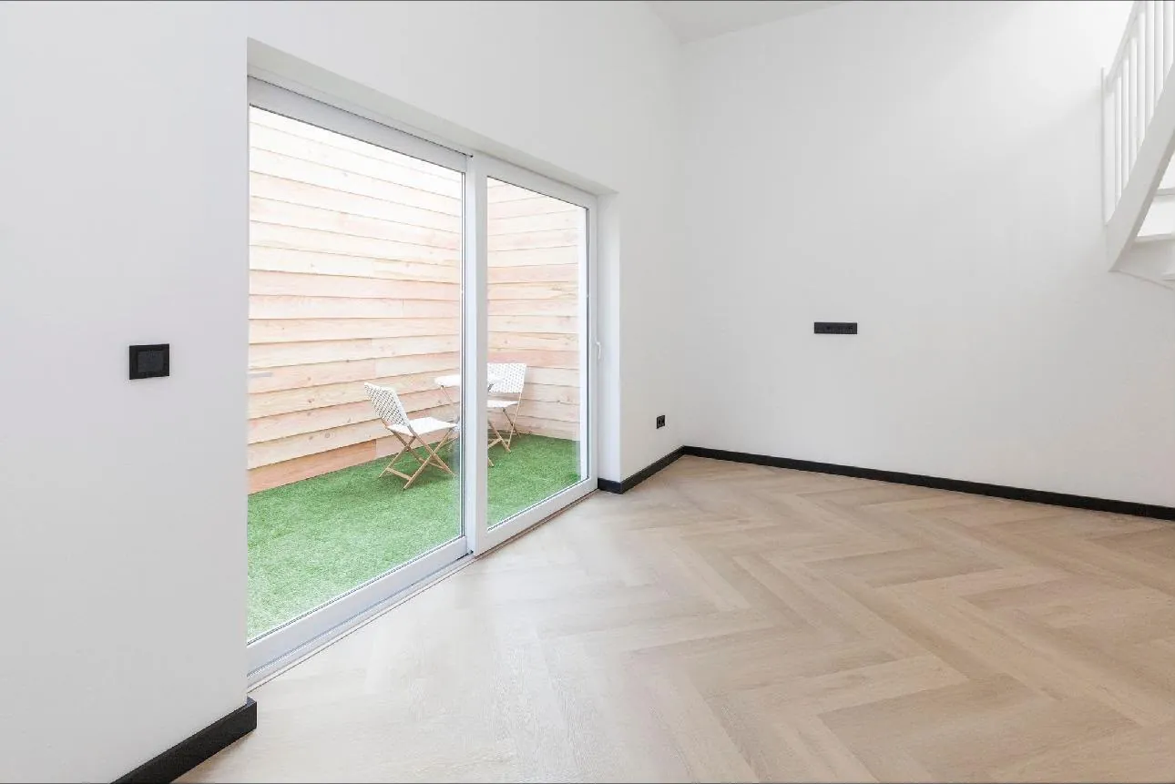 Gerenoveerde woonkamer met tuindeuren en visgraatvloer